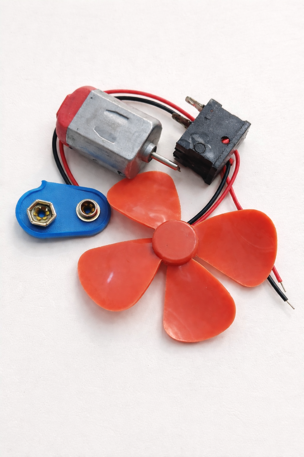 Small fan DIY kit with motor, battery connector, propeller, button and LED.